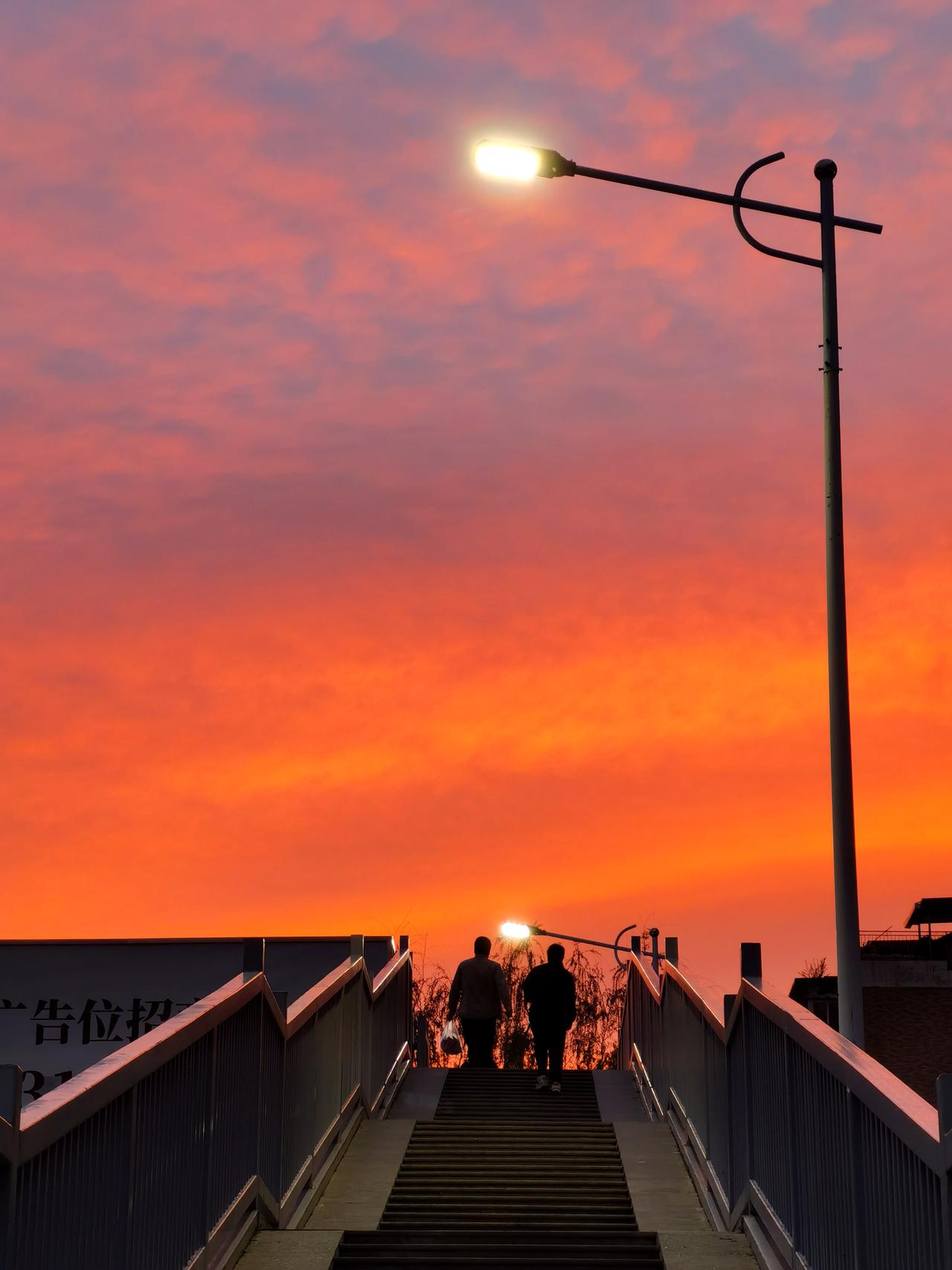 夕阳拼命染红了天空，路人只管埋头赶自己的路，路灯也提前上班凑凑热闹，多么美好的夜