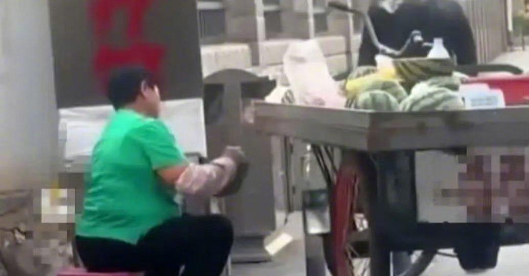 2026年5月20日，一名市民在开远市街头拍到流动瓜贩用水果刀蘸取无标签塑料瓶中