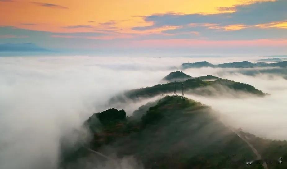 龙孔镇楠竹村出现壮阔的云海日出景观，朝霞漫天、云雾绕村，整个村庄仿佛置身于仙侠剧
