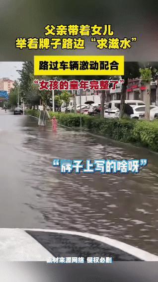 雨天路面积水，一位爸爸不走寻常路，带着女儿举牌路边“求滋水”。牌子一亮，路过的车