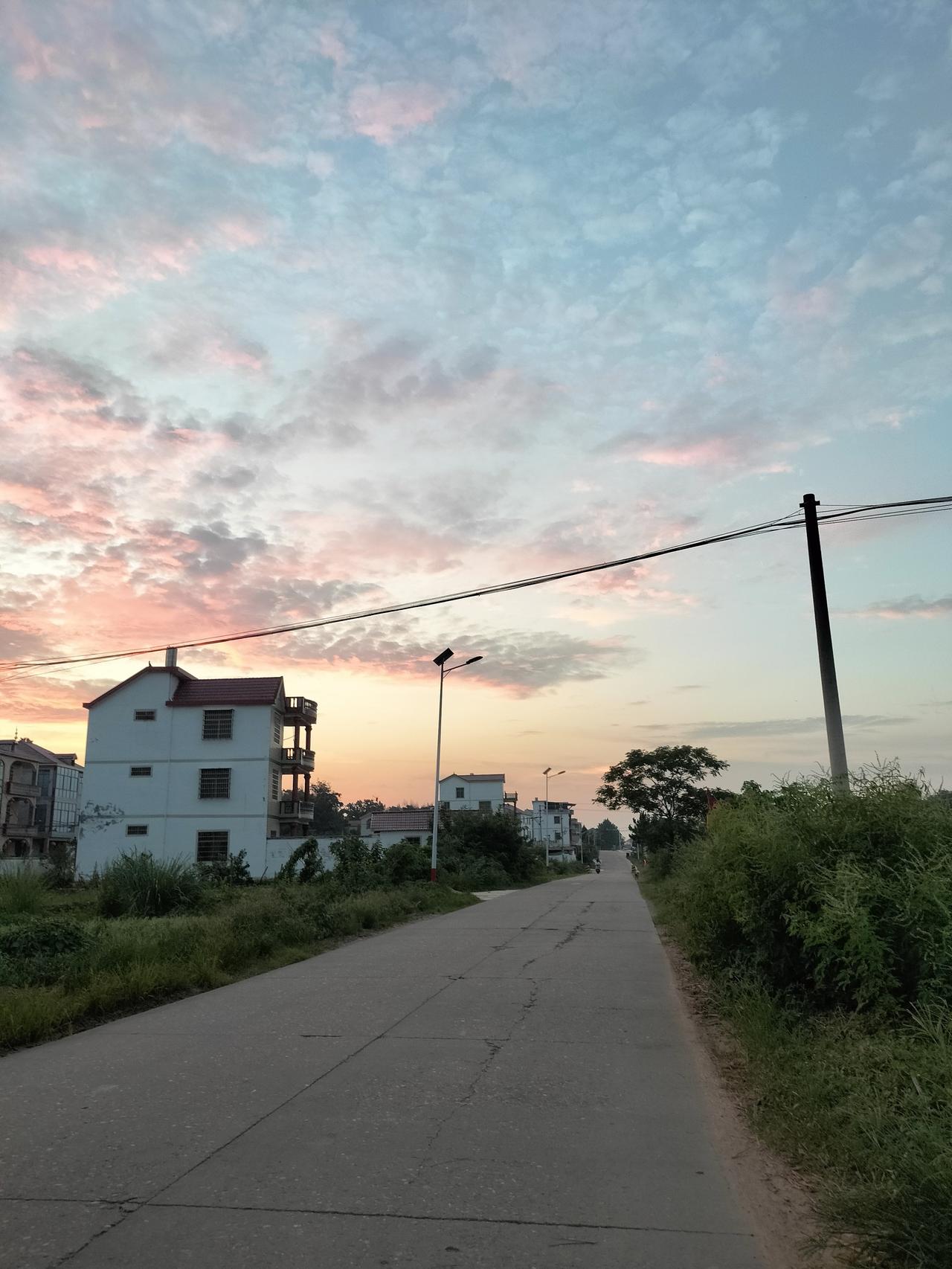 这是我的家乡万合镇湖尾村大队的房屋风景照，傍晚时分的晚霞格外绚丽多彩。

看到路