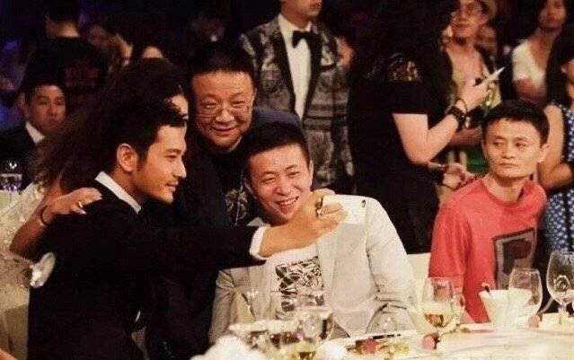 2012年，芭莎明星慈善夜十周年庆典，黄晓明坐在晚宴上与人自拍合影的画面。

那
