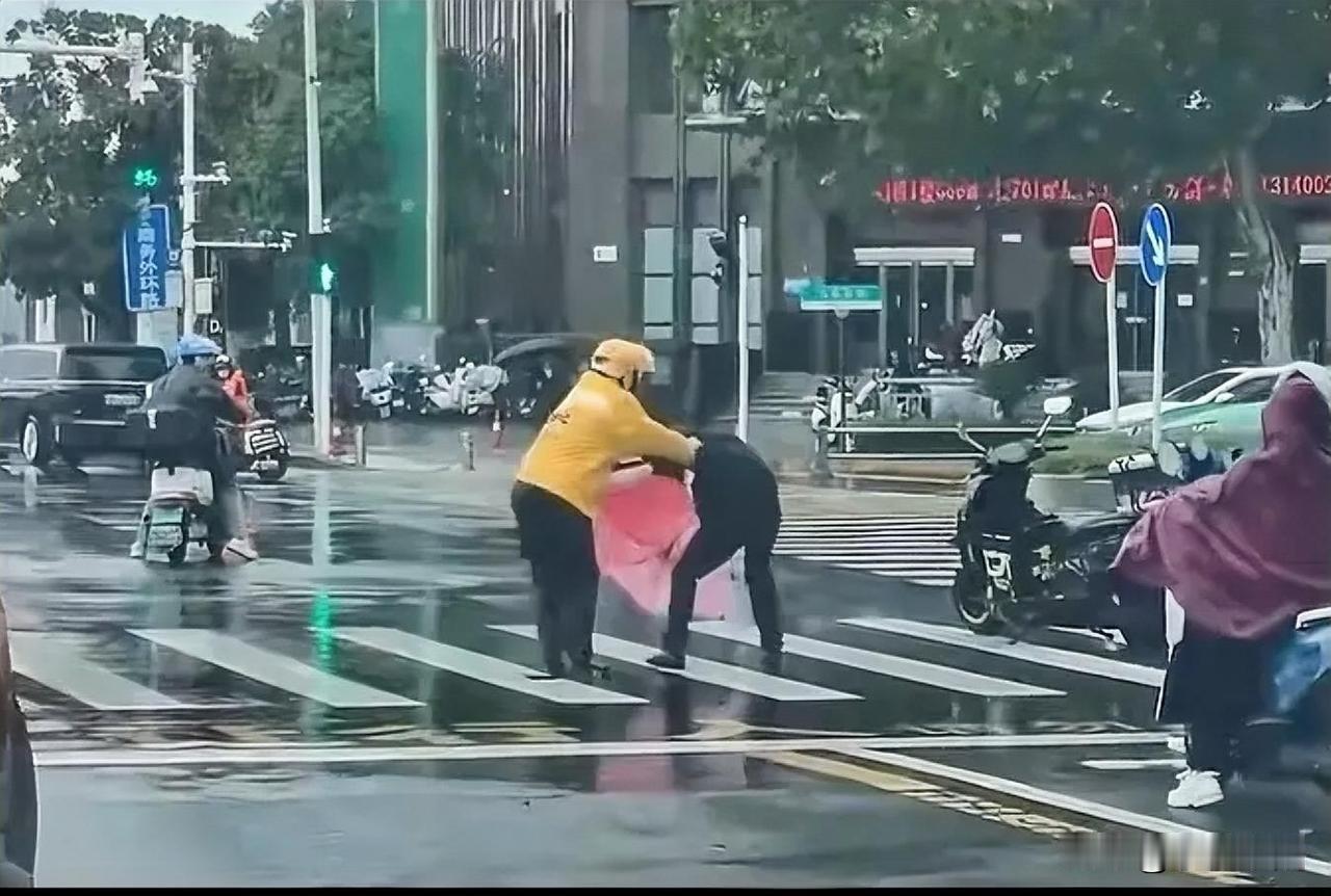 “别看小哥瘦，惹火把你揍，在一大街上，一黑衣男子踢了一脚摩托车后惹怒了外卖小哥，