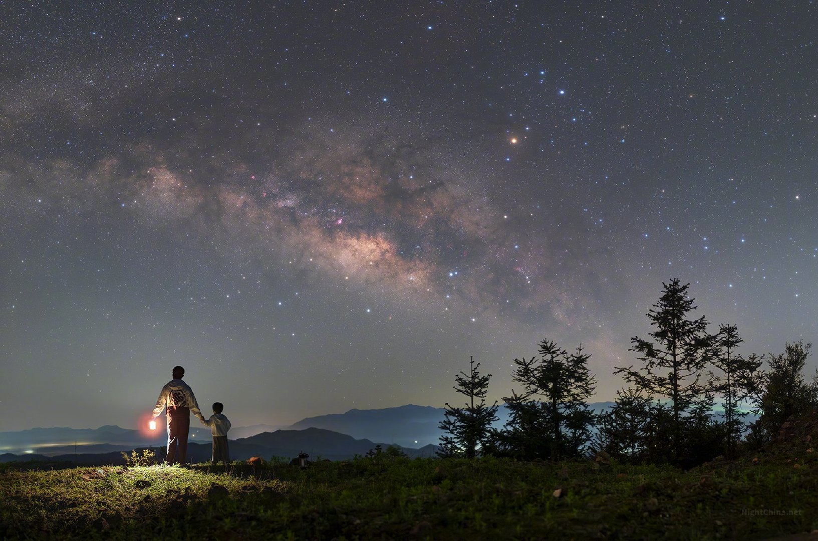 灯火在山顶轻摇，银河在头顶宽展。星与星之间的距离以光年计，而你与我之间的距离，不