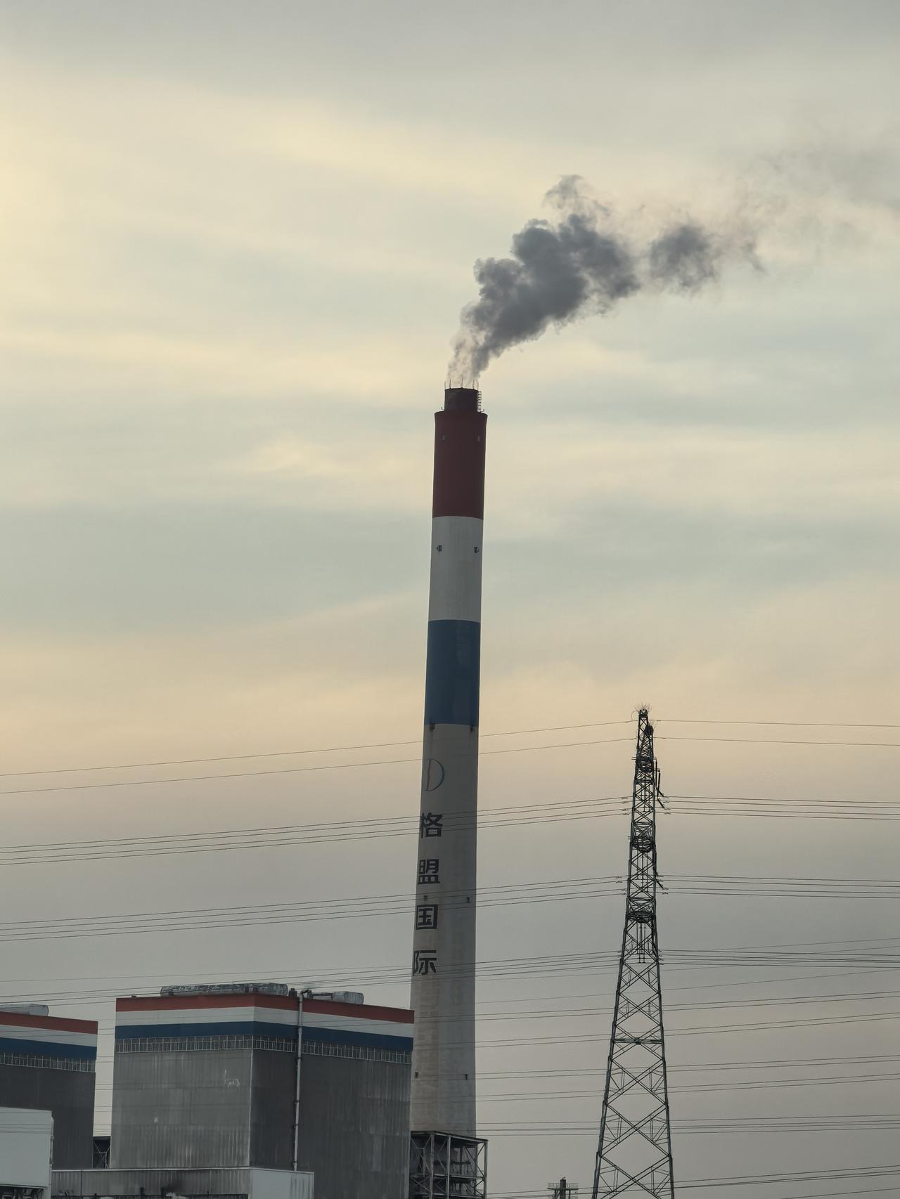 我手机里最美的风景有一张烟囱照。那是出门时随手拍的，画面里烟囱像个屹立云端的巨人