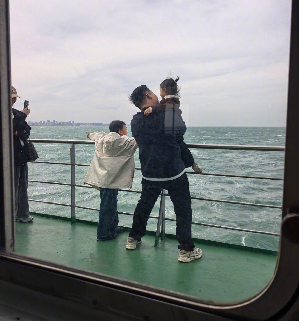 爸爸抱着小棉袄在风大浪急的船边玩耍，昨天琼州海峡渡轮上看到的一幕。一家四口看到大