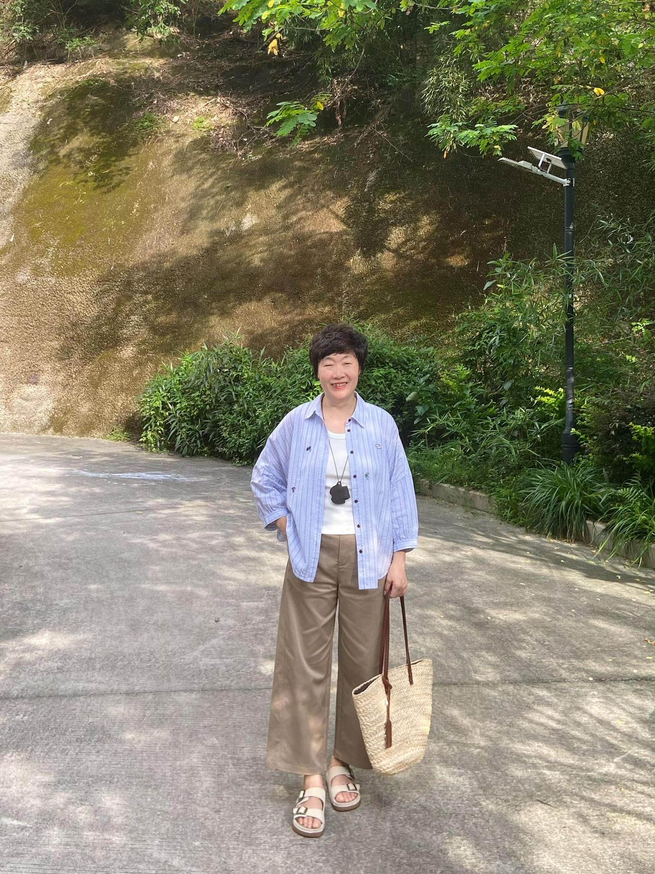 太喜欢这个阿姨了，无龄感穿搭很松弛！
浅蓝条纹宽松衬衫内搭简约白色背心，版型舒适