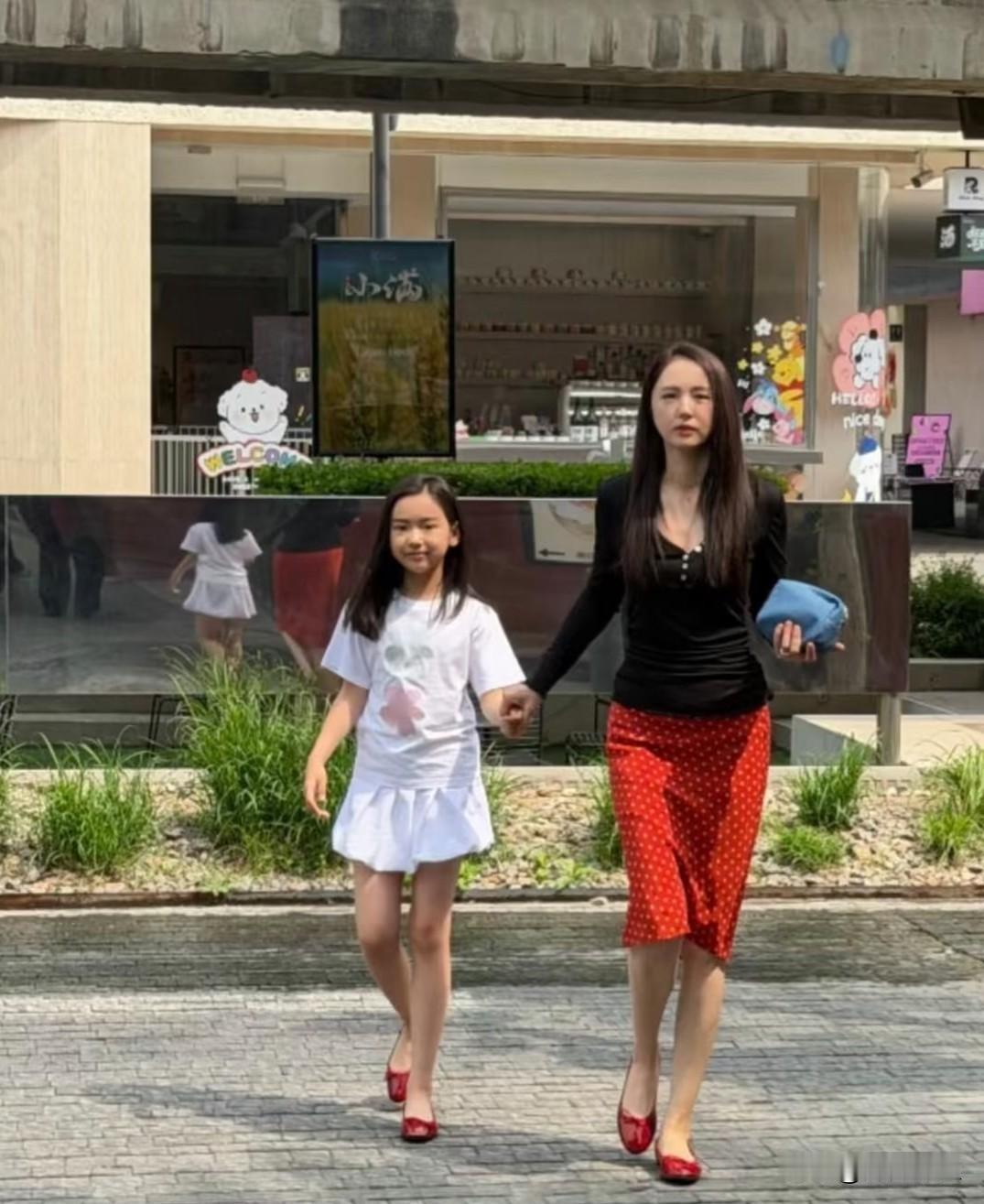 董璇和女儿外出被偶遇！

一身黑色修身上衣搭配红色波点半裙，红色高跟鞋亮眼复古，