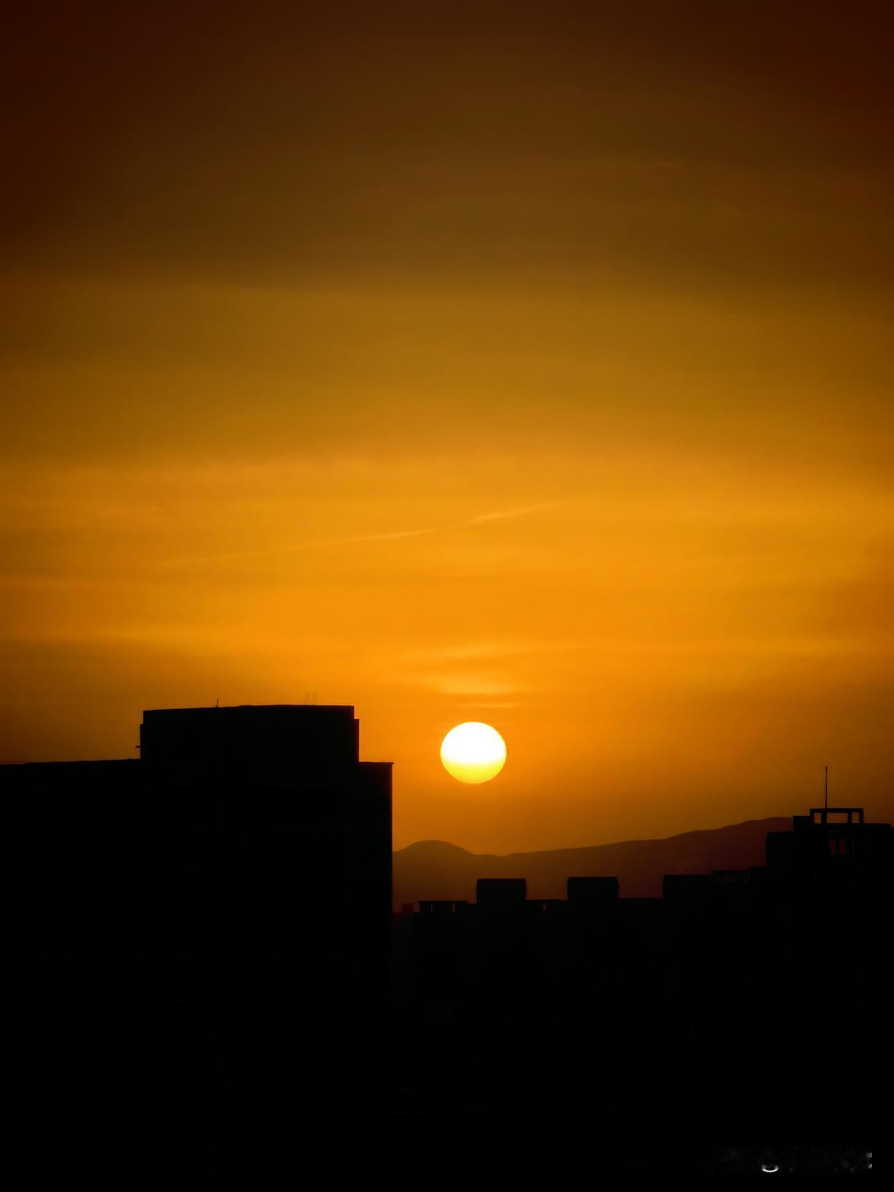 西部摄影 夕阳捕手 暮色漫过城市的檐角时，落日正悬在楼宇的缝隙间，像一枚滚烫的金