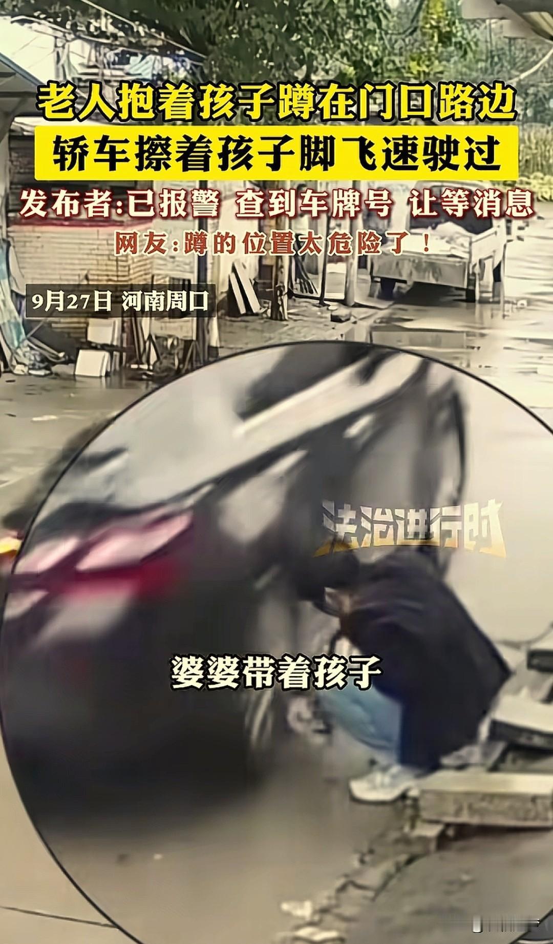 河南周口，一老人蹲在马路边抱着孩子正哄着玩，突然一辆小轿车疾驰而过，车轮刚好擦过