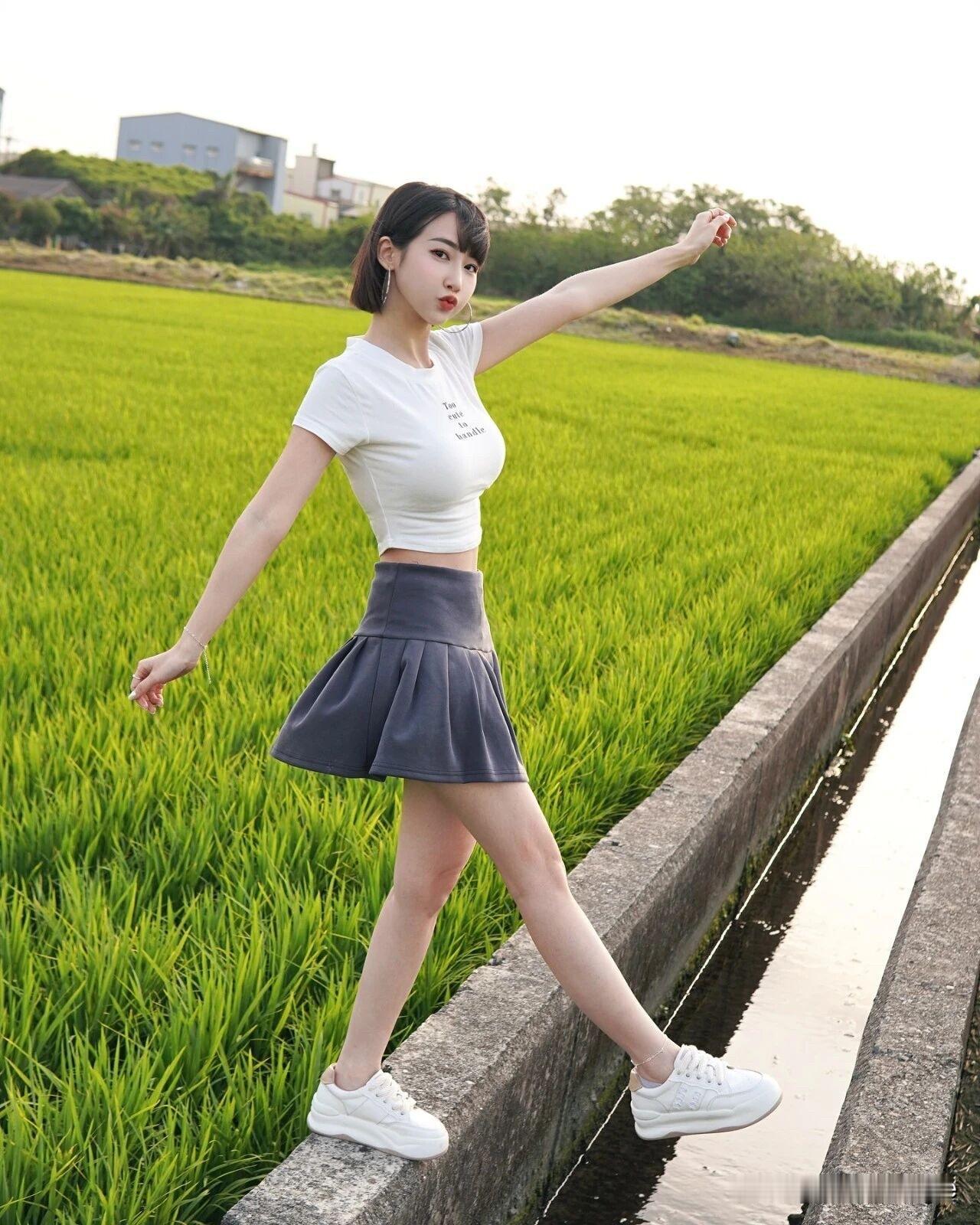女孩坐在田埂上，笑得很甜。