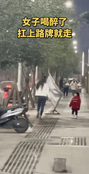 好女也不敌酒多，女子为女子扳回一局。
不过，她真的是要把路牌抗到家里去吗？
大概