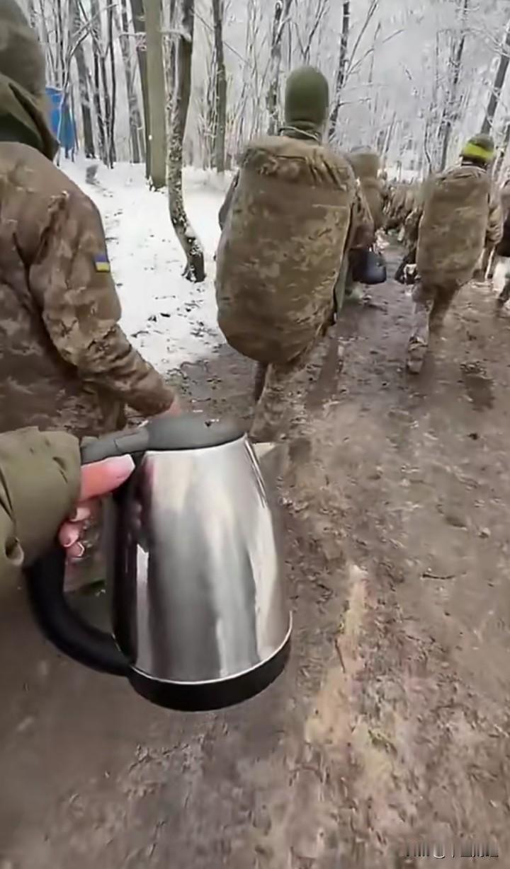 一队乌克兰士兵，行走在冰天雪地的树林中，然而，看看这名士兵拿的电水壶，似乎与网络