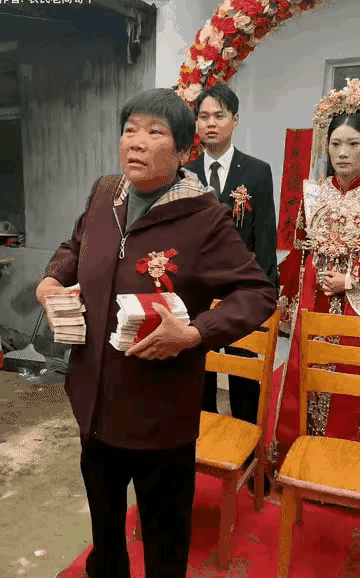 这个老大妈在女儿的婚礼上，一手拿着一沓子钱，目测沉甸甸的，总数最少在20万以上，