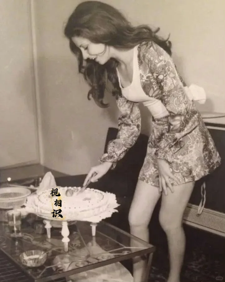 1973年，伊朗，一位打扮时髦的女郎正在切着生日蛋糕，镜头中可以看到她的体态窈窕...