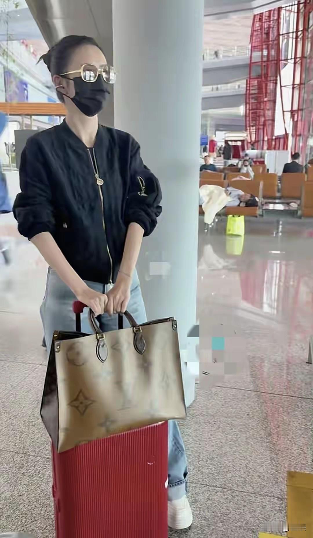 佟丽娅机场扎起头发，黑色外套配浅蓝牛仔裤