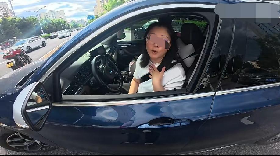 宝马女车主从停车位上出来准备掉头，差点跟正常行驶的摩托车发生剐蹭，双方停下车理论
