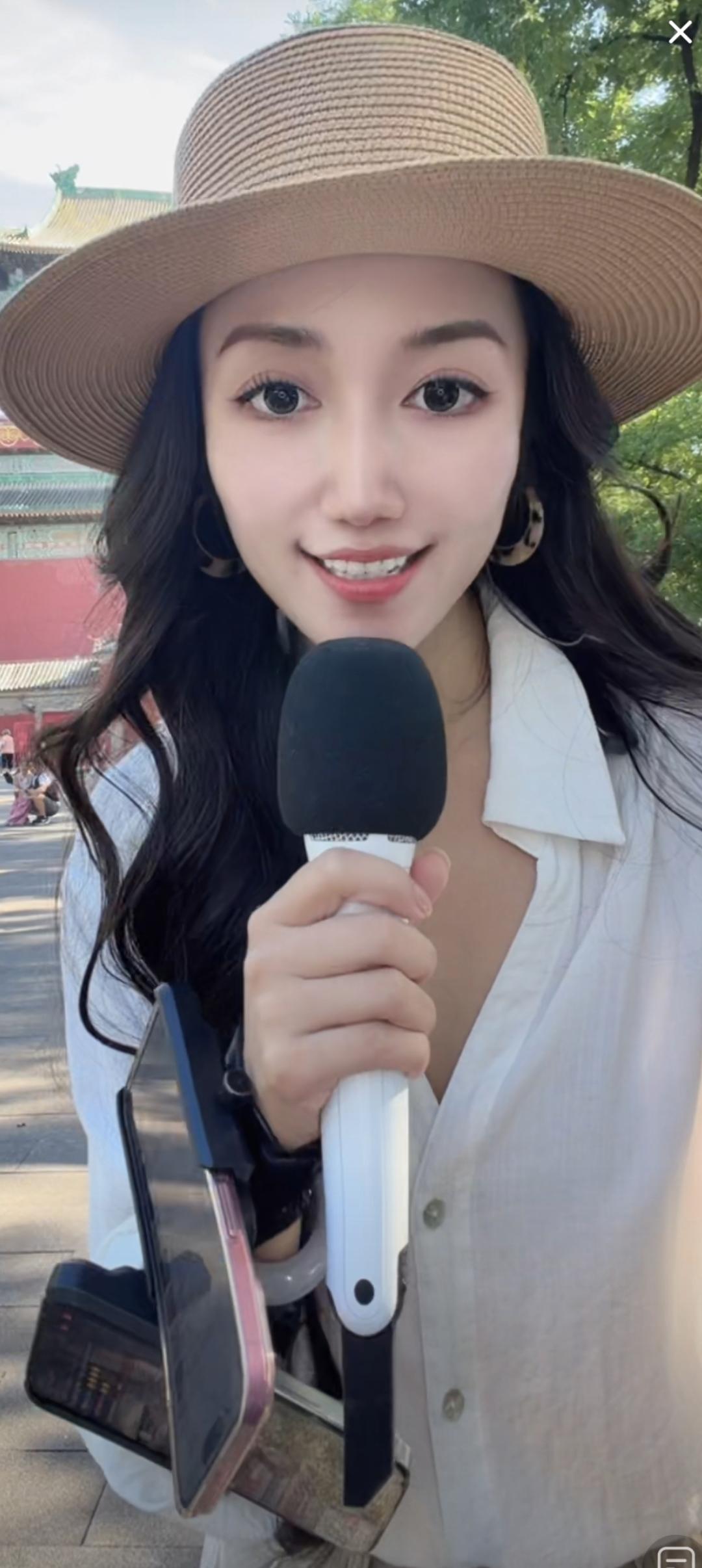 这位小姐姐正在户外采访呢。