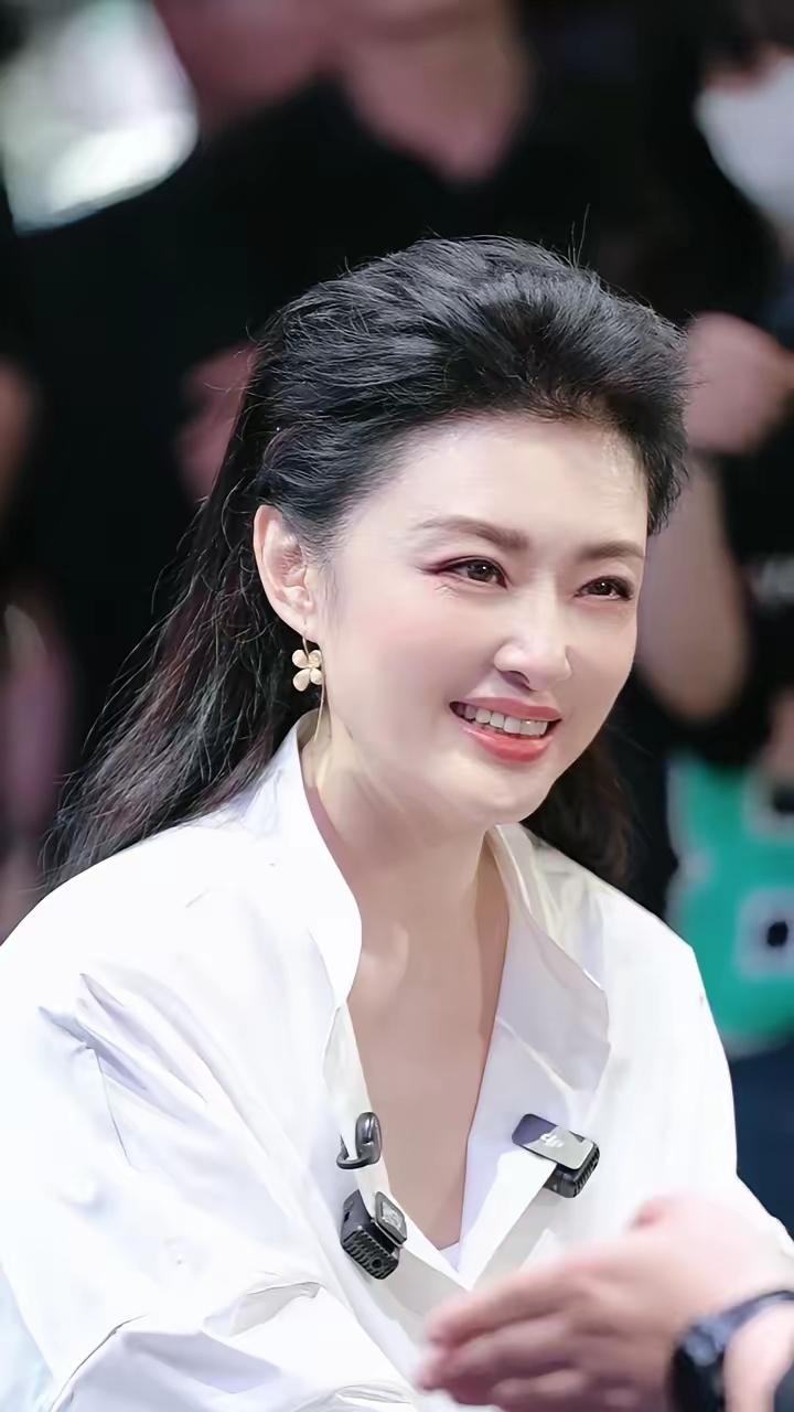 周涛一身简约白衬衫，半扎长发，笑起来温婉动人。历经岁月沉淀，从容优雅的气质由内而