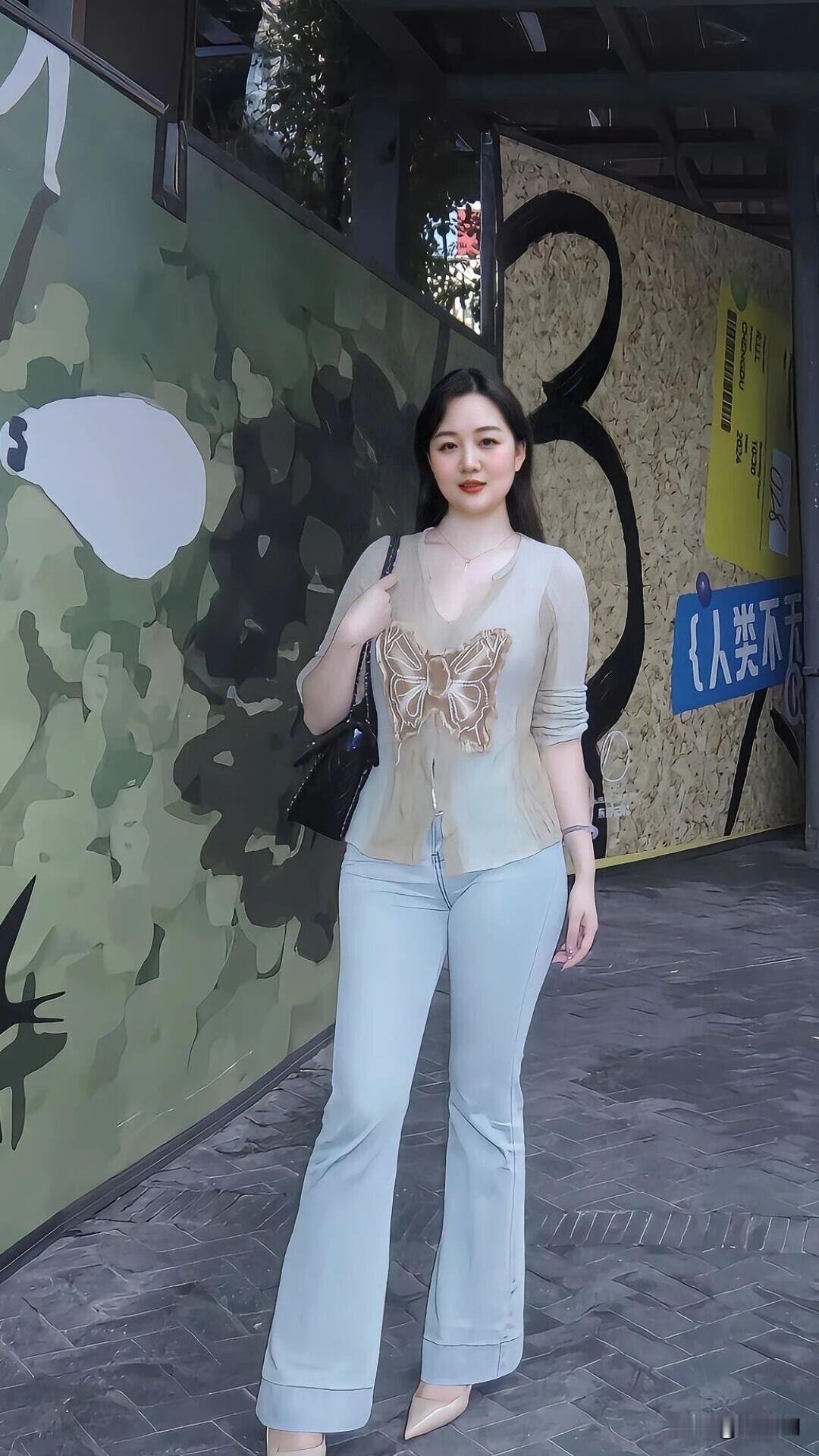 轻衫叠雾缀蝶光，浅裤裁风曳巷长。
鬓发垂肩春未老，笑涡衔暖日初阳。
包悬墨色添清