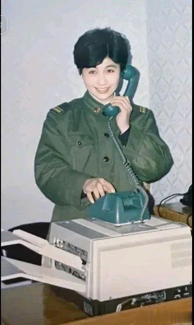 90年代，一名漂亮的女兵，正在与家人通电话，从照片中可以看出来这名女孩的颜值丝毫