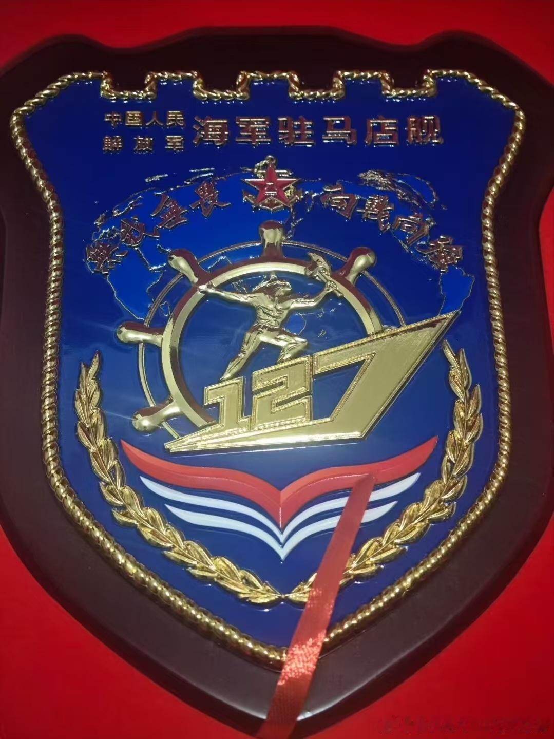 127“驻马店”舰舰徽，052D型27号舰，中央是舷号127组成的军舰轮廓，中间