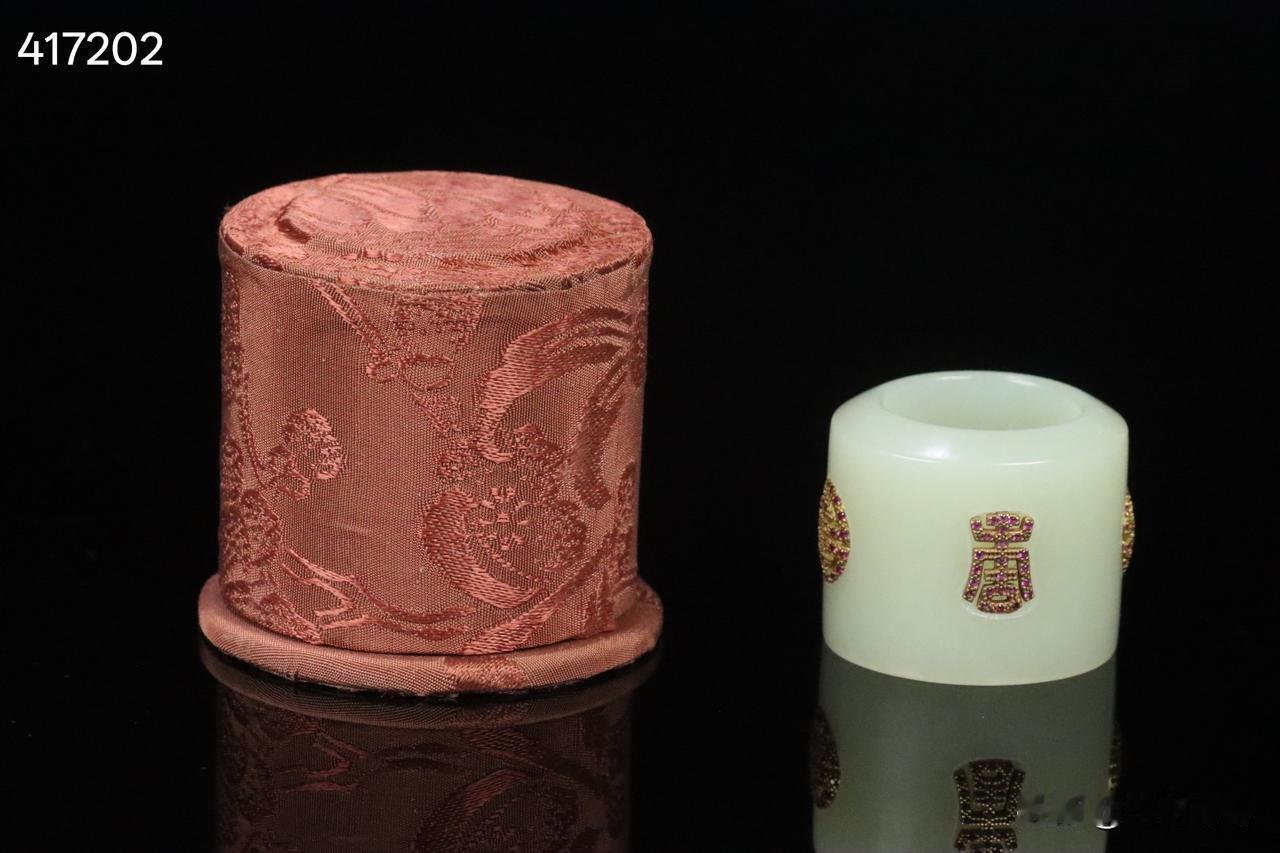 晚清  和田玉嵌银鎏金团寿纹扳指 带老绣布扳指盒一套。

规格：2.9*3.7*