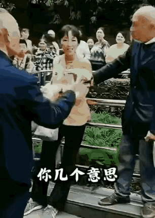 公园内两位男性老者对女性舞伴发生争执引起很多群众的围观，下面老者对着台阶上女人和