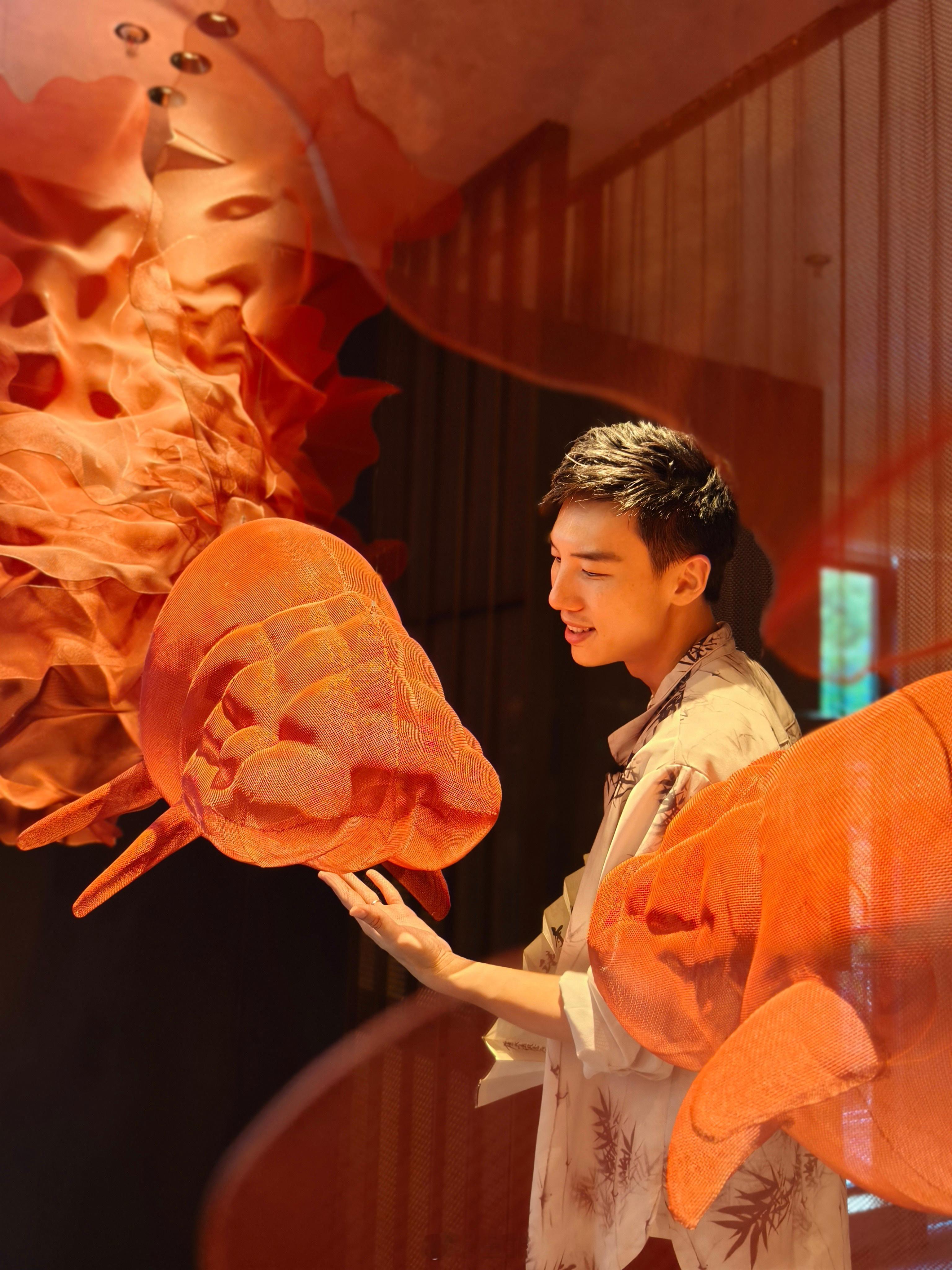 水雾缥缈，石榴花开的鱼尾似水墨在空中晕染，双尾锦鲤迎门，有种笔墨酣畅的写意。一方