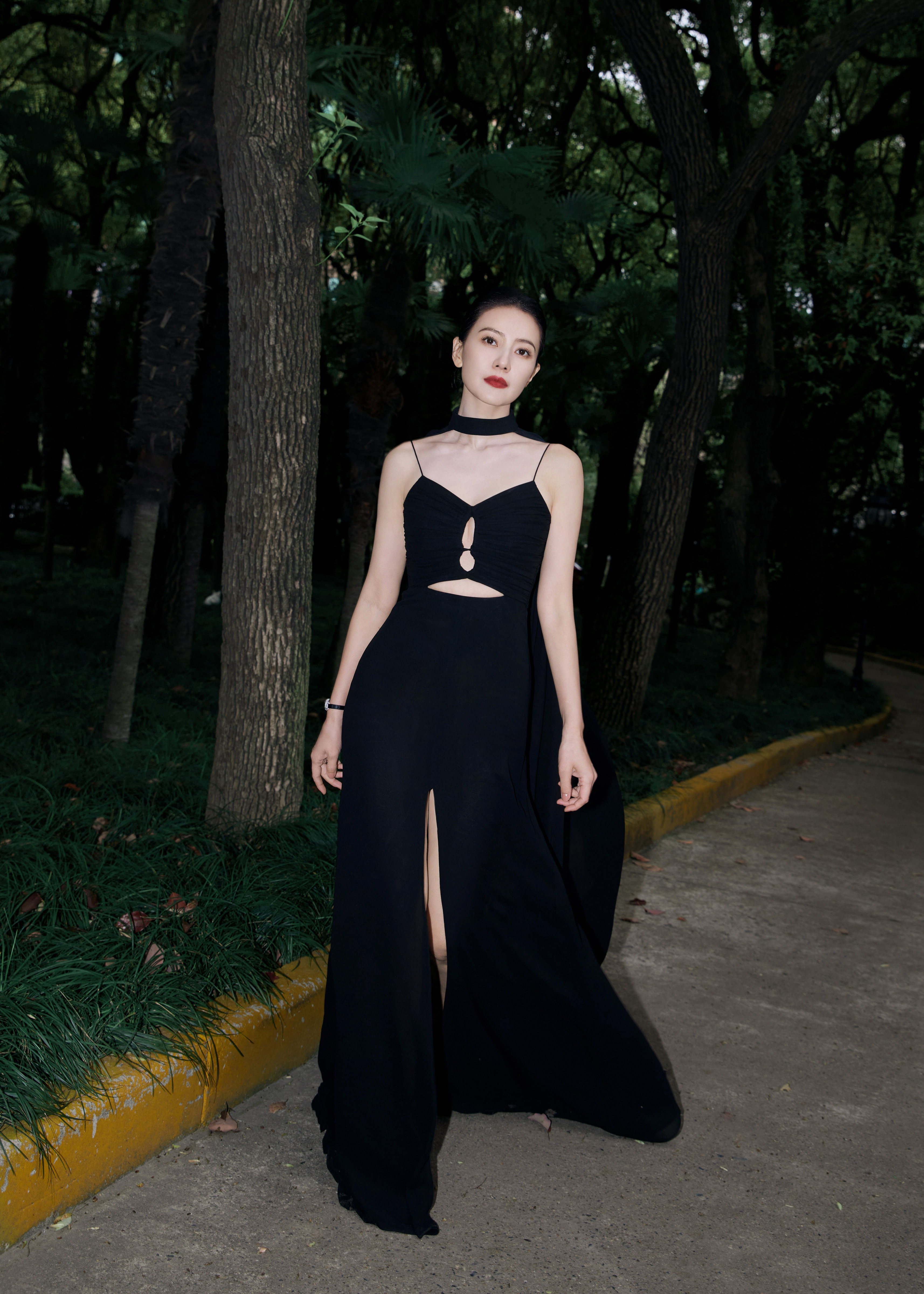 早上好以浓绿的园林为底色，营造出静谧又高级的氛围感。一袭黑色吊带长裙利落勾勒出流