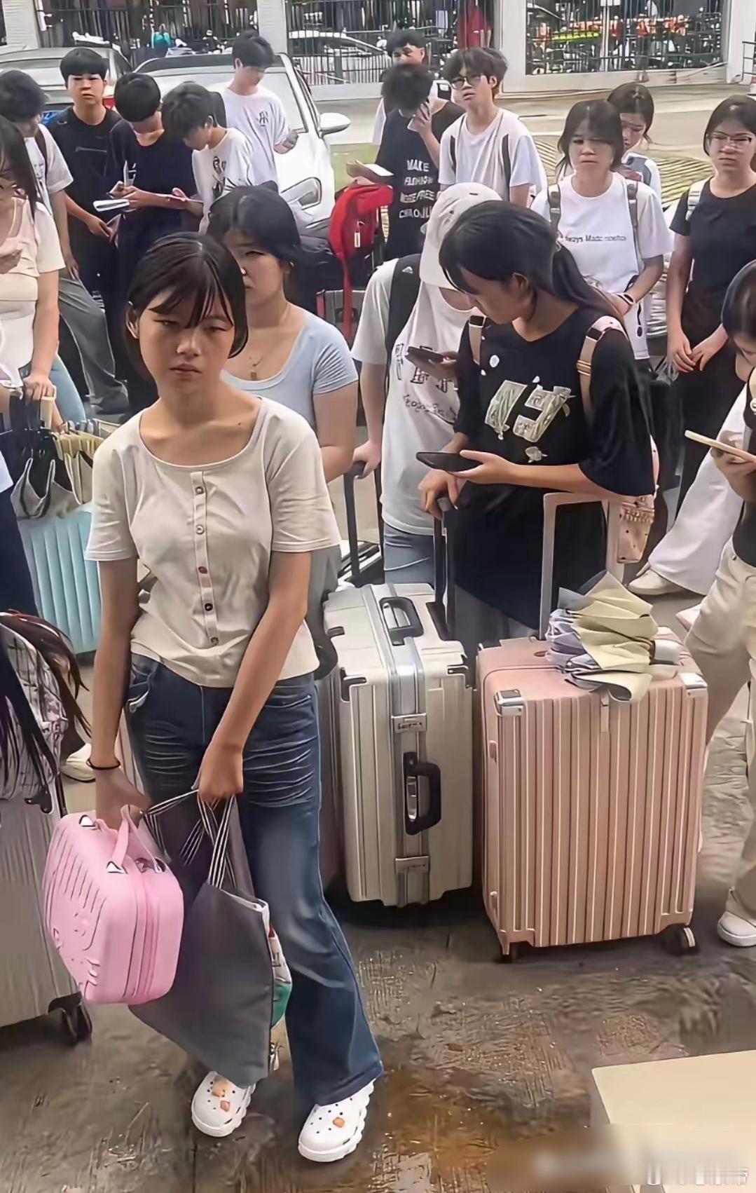 一群稚气未脱的年轻人，也许是刚刚毕业的职校生，在等待进厂 