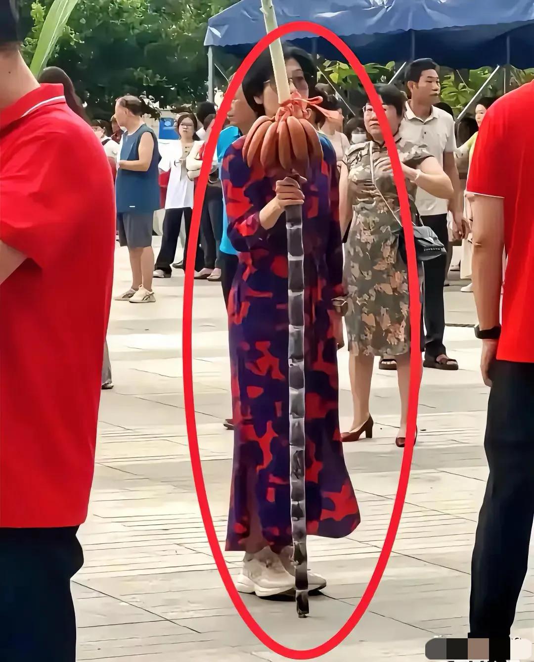 高考场外的一位母亲。身穿旗袍，旗开得胜；脚蹬波鞋，劈波斩浪；手拿甘蔗和香蕉，粤语