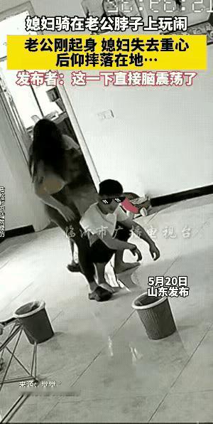 这对年轻小夫妻，秀恩爱时忽视了安全。只见男的蹲在地上，女的抬腿骑在男的肩膀上，男