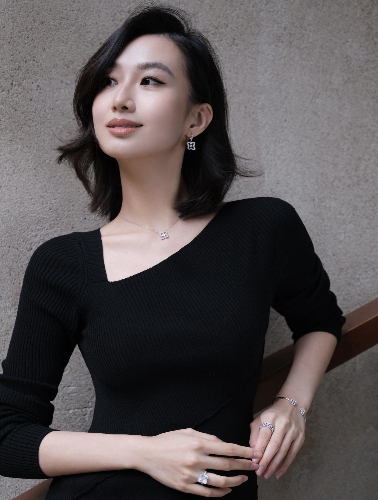 优雅黑衣少女，精致耳环与项链点缀，散发迷人魅力。黑裙感美女