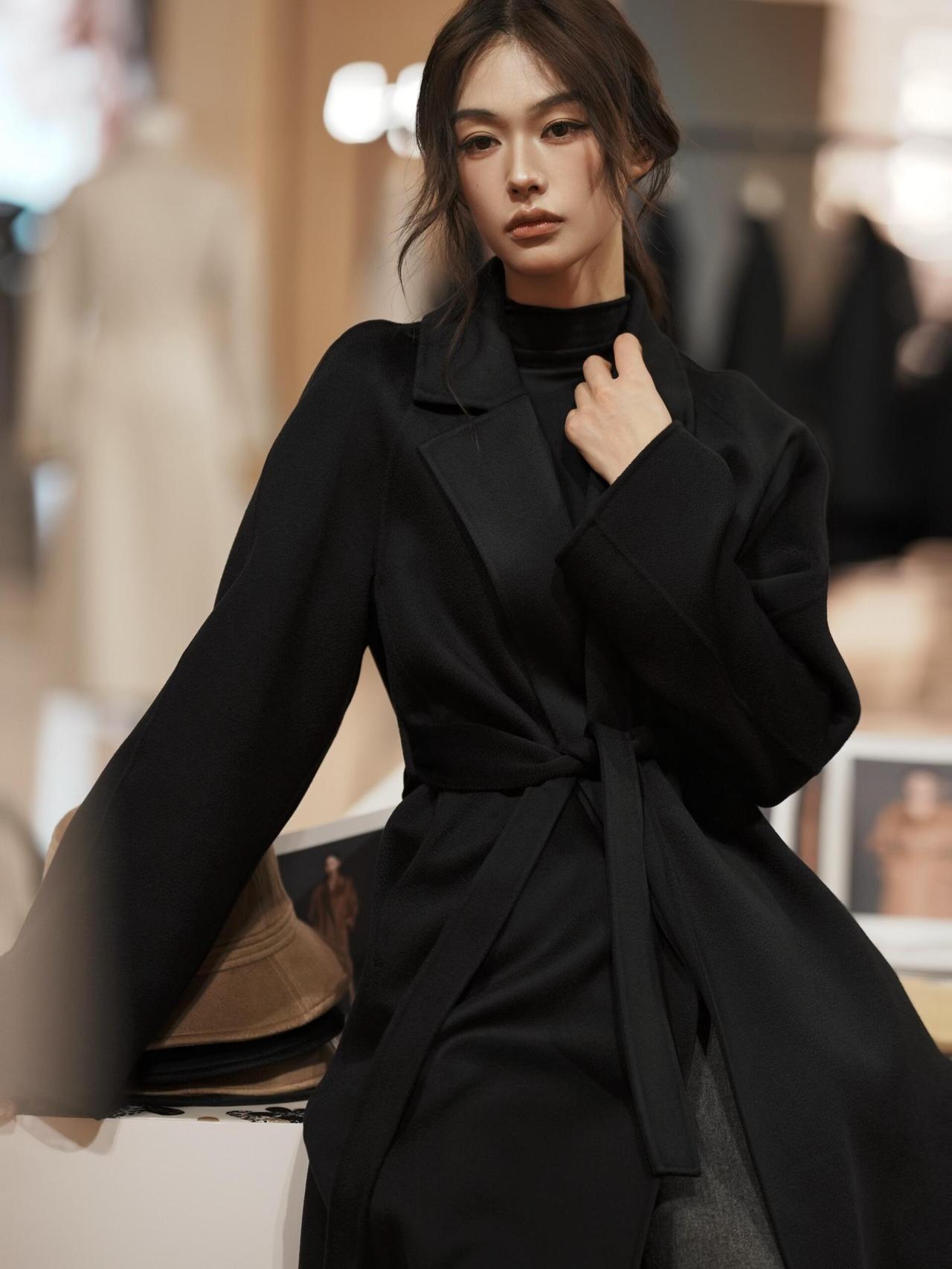 同元素的风格反差，黑大衣版本以“冷感锐利”为核心：高领内搭收紧线条，腰带强调腰线