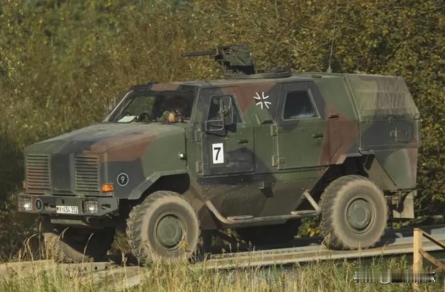 1名乌军壮汉在巴赫穆特前线拍照，看起来很高兴，后面是一辆被摧毁的德国货“野狗”2