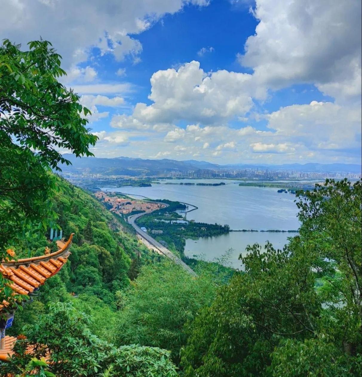 连绵山峦静卧湖畔，宛若安然酣眠的睡美人，苍峰叠翠满目清葱。山间林木幽深葱茏，烟岚