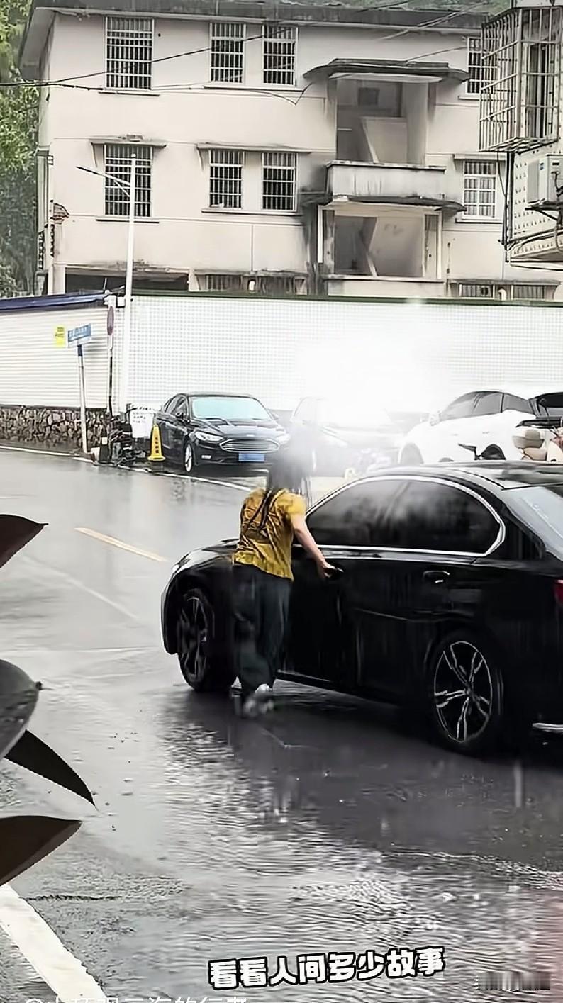大雨中，女子拽着车门把手不松开，那意思是不让开车的人走。
这明显就是情侣闹矛盾了
