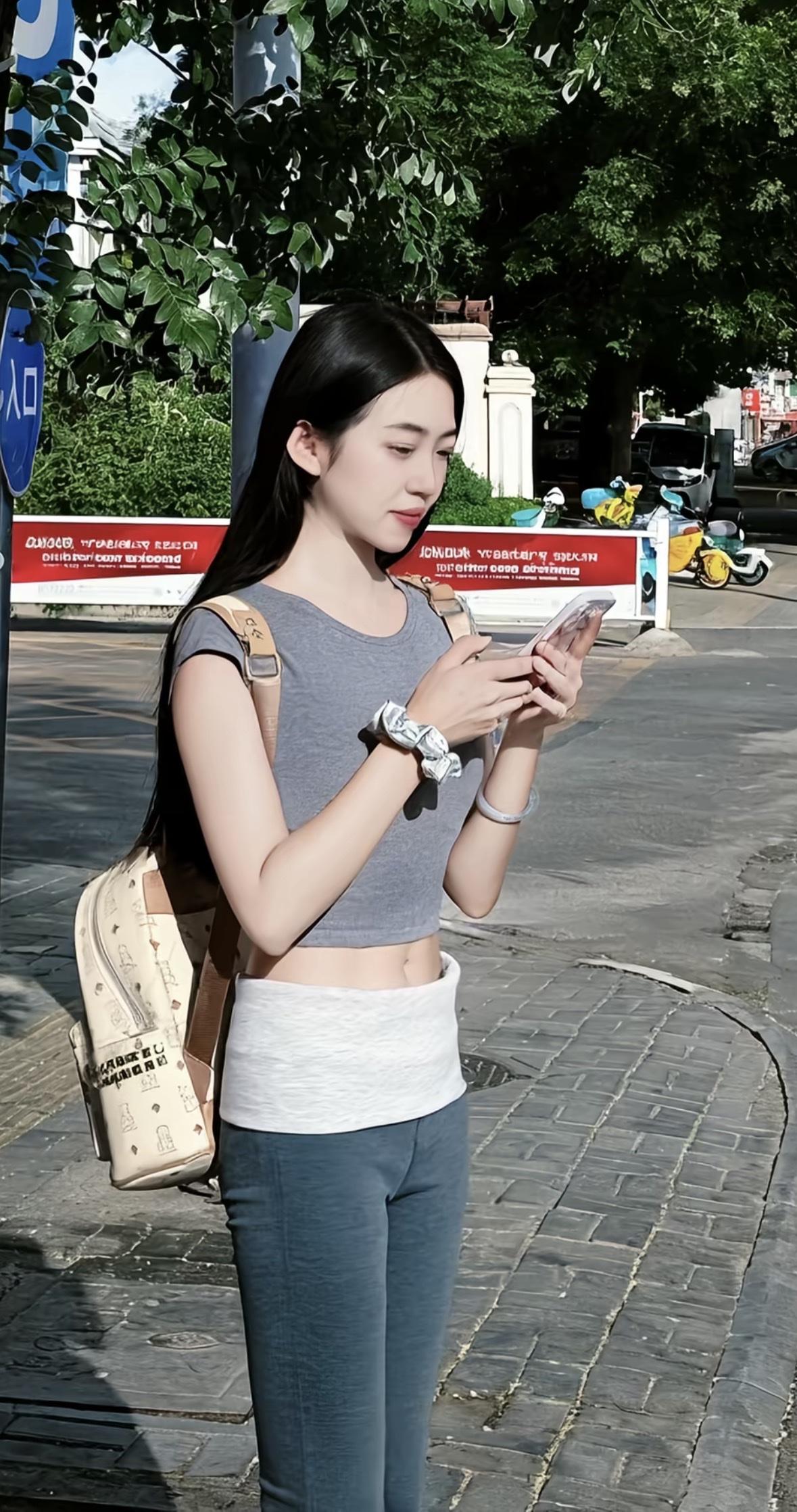 妹子在路边看着手机等车