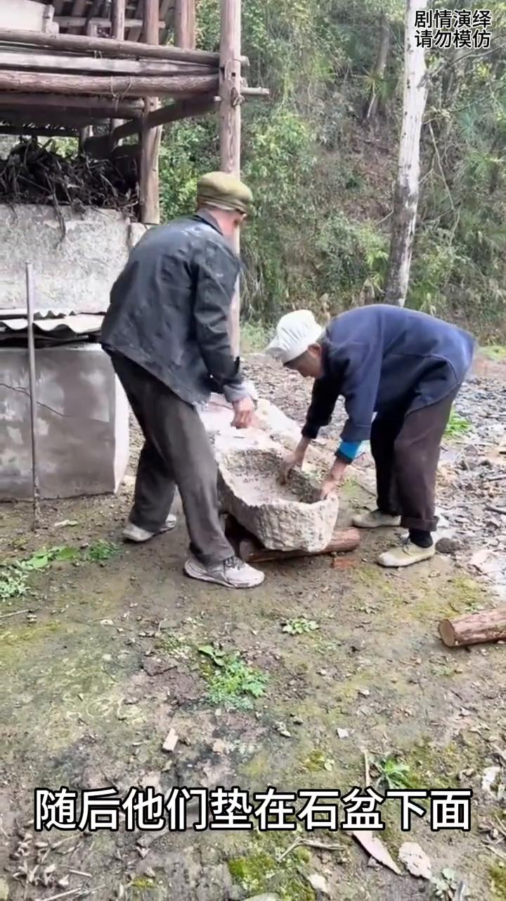 大叔大婶巧妙用木头挪走石盆，这一幕真的太有才了。
大叔大婶在挪石盆，只见他们将石