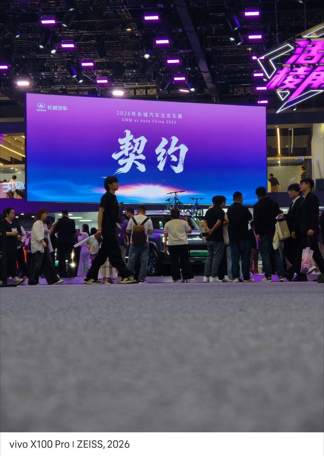 紫幕高悬映誓盟，人群攘攘踏春声。长城志在新途远，契约如磐向远行。北京车展潮这看北