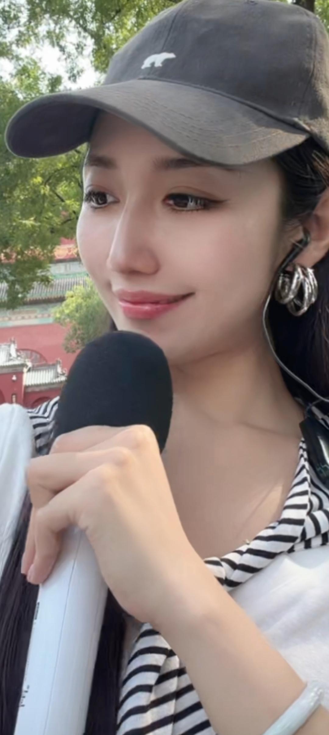 戴着帽子的女生在户外说话。