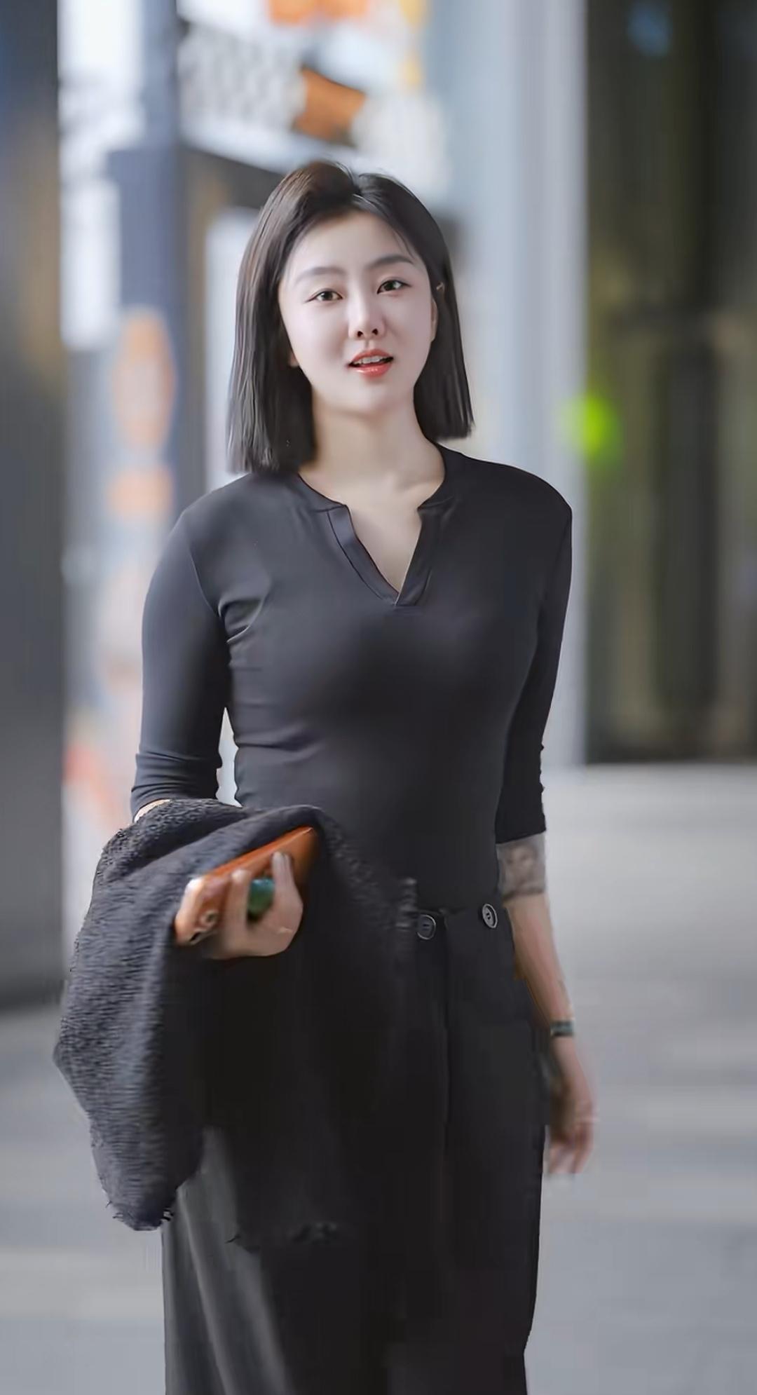 都市时尚穿搭，黑色V领上衣搭配黑色长裤，简约而不失优雅。