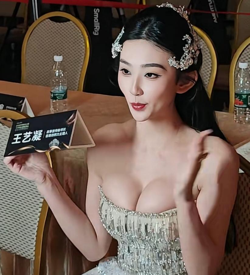 王艺凝在干什么？原来她坐在桌前，手持自己的名牌对着镜头展示，正在参加某个活动。