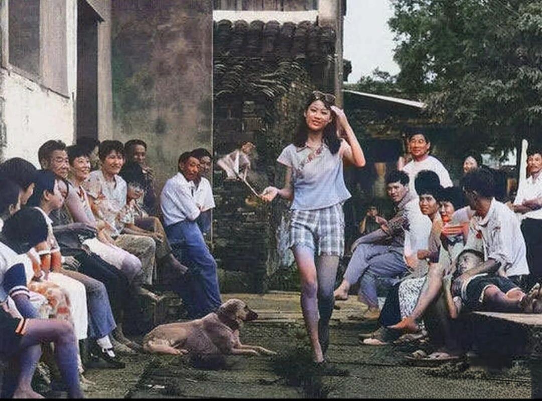 看看你们的无意间翻到的老照片改开之初，一个女孩儿穿着短衫短裤从弄堂走过，街坊邻居