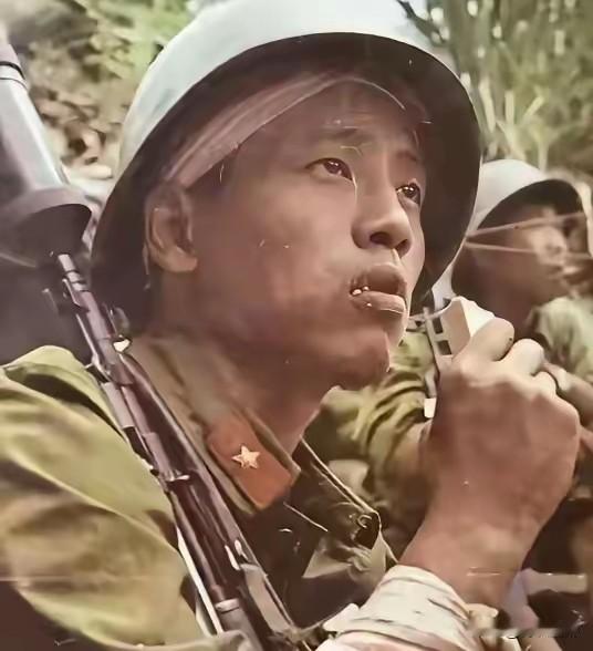 1987年4月20日 ，在老山战役，越军手持喷火器，喷向我方弹药库，一名嘴啃压缩