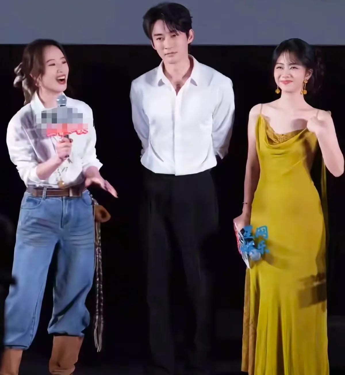 左边笑容灿烂的是李梦，右边身穿淡黄色长裙，抿着小嘴的是谭松韵。中间这位身穿白色上