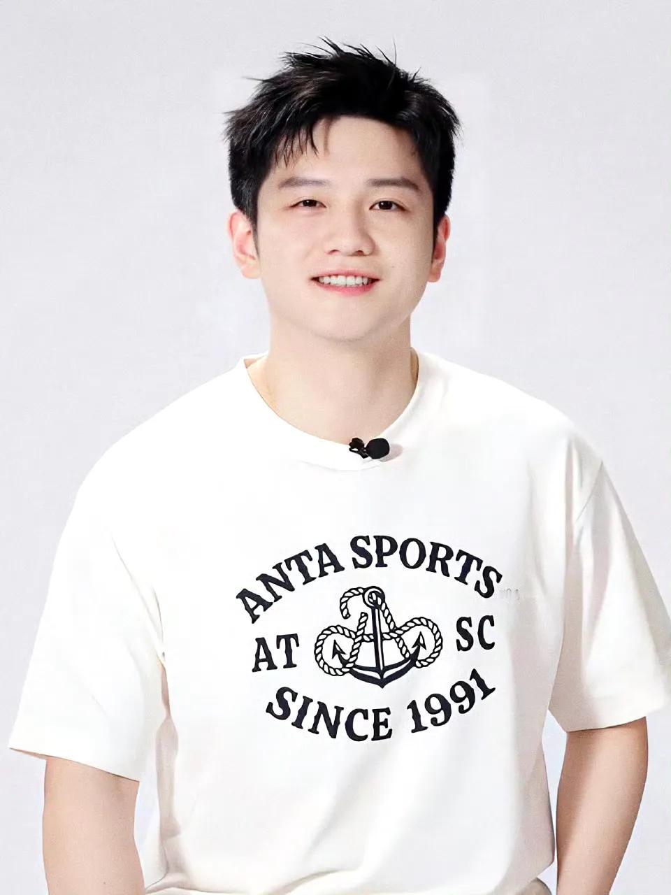 一身白衣，在配上白皙通透的脸庞。就问你这样微笑的小胖樊振东可不可爱，帅不帅。这笑