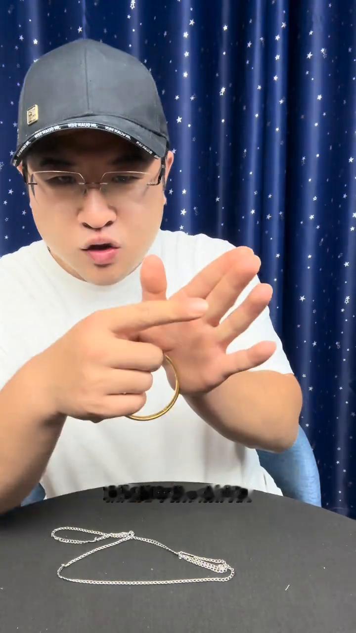 高手在民间：盯住铁环，大叔表演铁环穿铁链。
现在来教学一下为什么把一个金镯子放到
