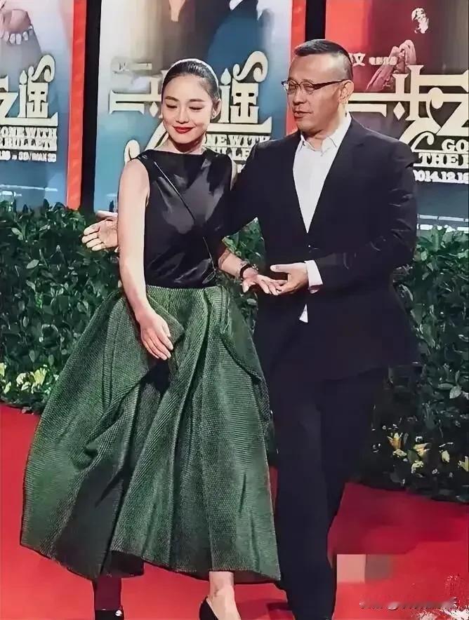 这是一对夫妻出席活动的合照，男士的手扶着女士的腰上，默契十足，充满爱意，构成幸福